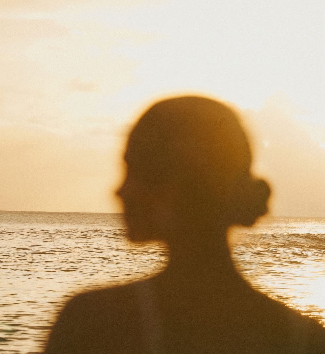 A silhouette against a golden sunset over the sea